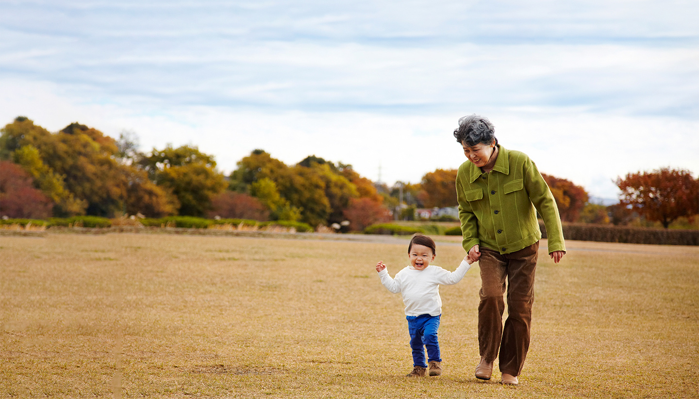 older woman and toddler walking together outside